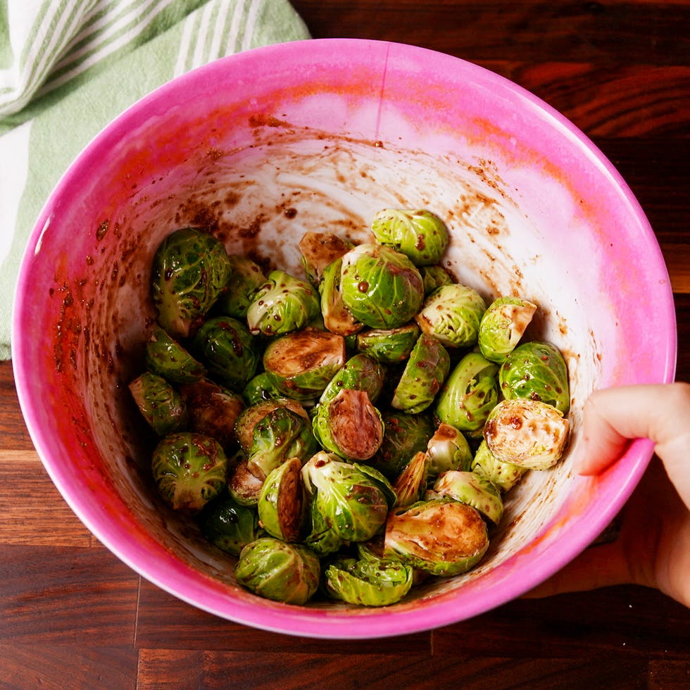 marinating brussels sprouts in a bowl