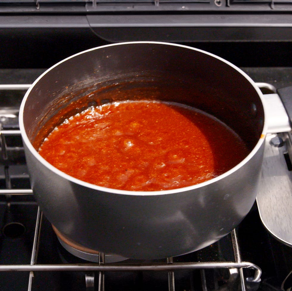 cooking sauce in a metal saucepan on a stovetop