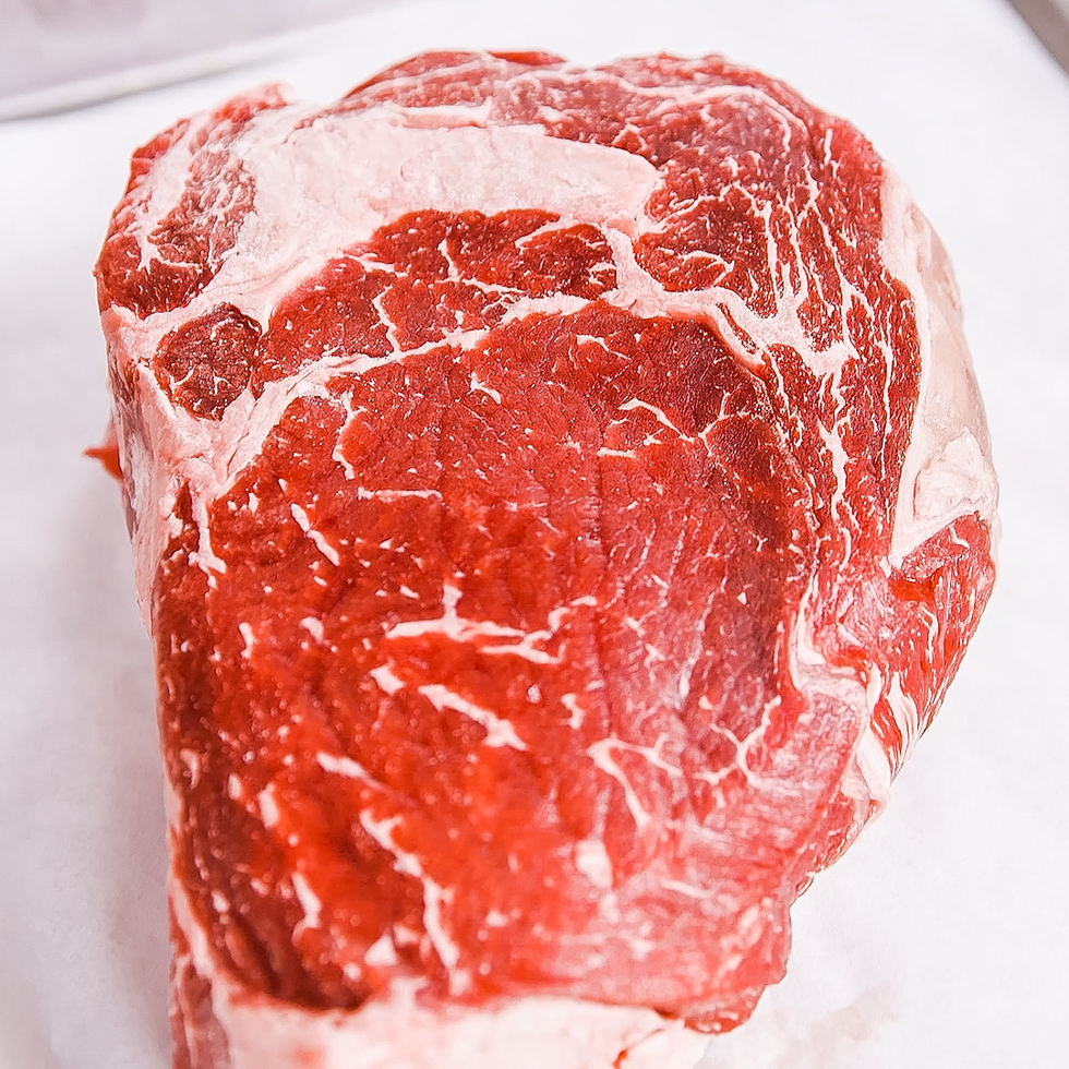 raw ribeye steak with marbling on white paper