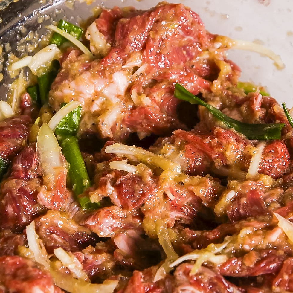 massaging marinade into thinly sliced steak