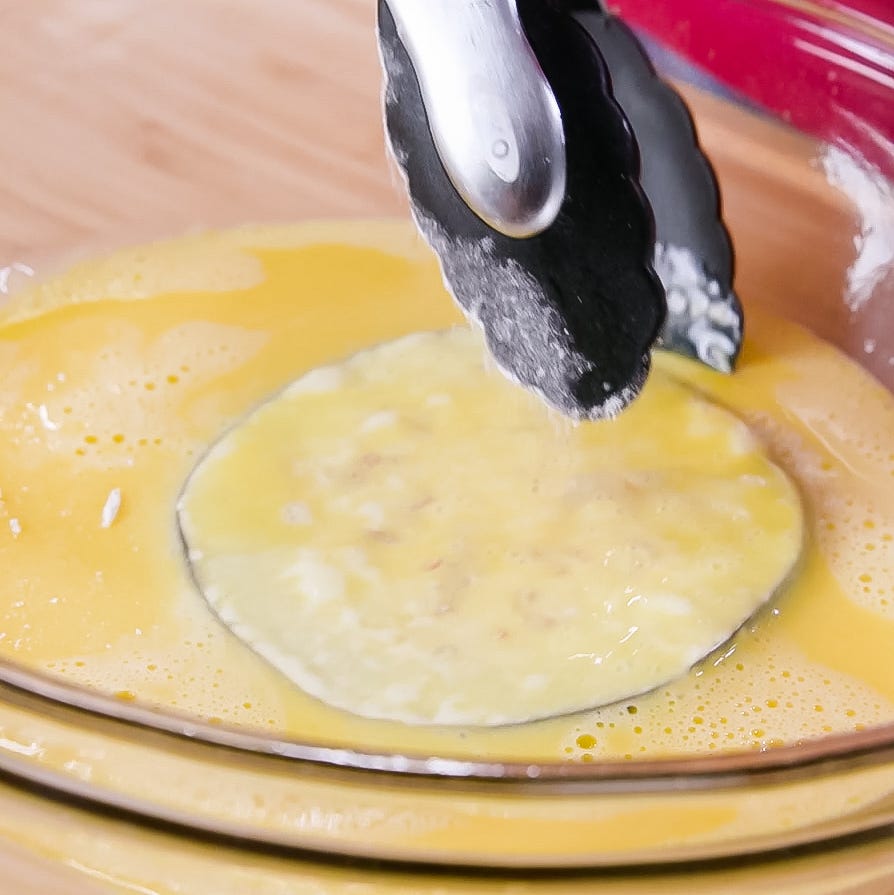 mixing beaten eggs in a bowl with a tool