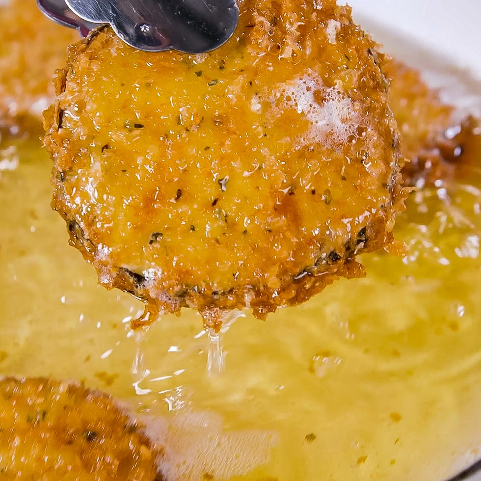 fried goldenbrown round food being lifted from hot oil