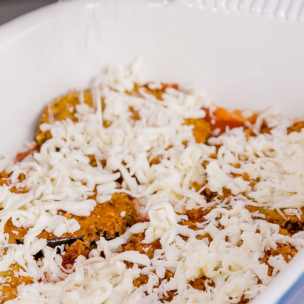 baking dish with layered ingredients and shredded cheese on top