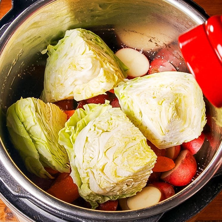 vegetables prepared for cooking in a pot including cabbage and various root vegetables