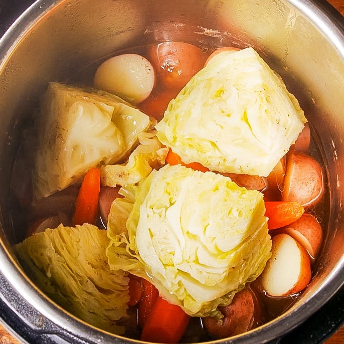 cooking vegetables and sausages in a pot