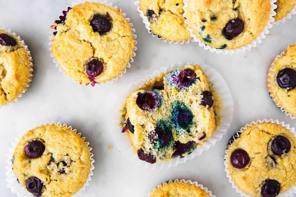 keto muffins with blueberries in cupcake liners, center cupcake split in half