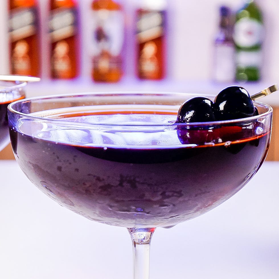 cocktail in a coupe glass garnished with cherries