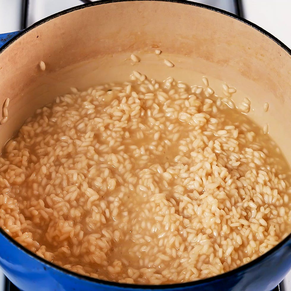cooking risotto in a blue pot on a stove