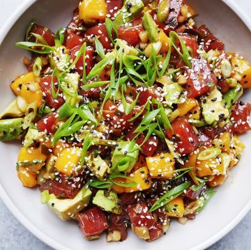 avocado mango poke salad topped with black and white sesame seeds and sliced green onion