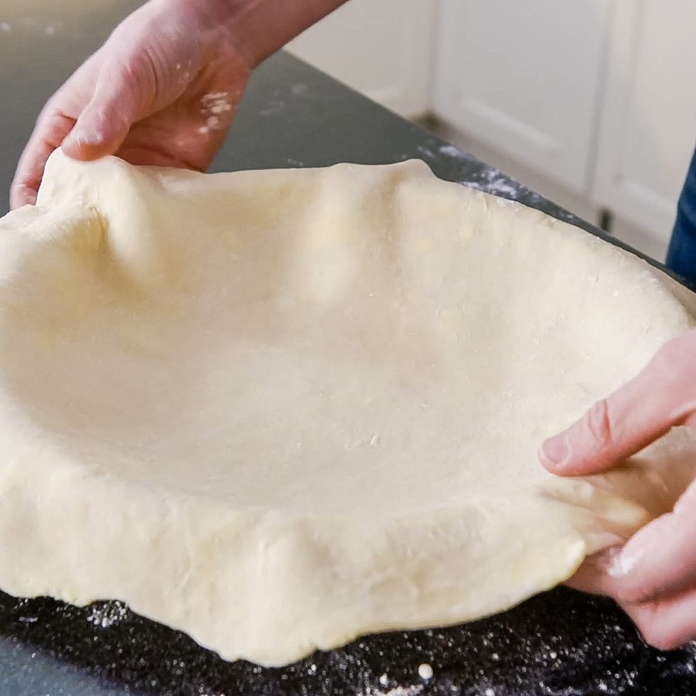 hands shaping dough into a crust