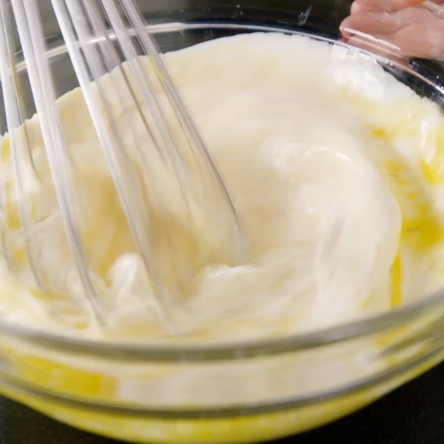 mixing ingredients in a glass bowl using a whisk