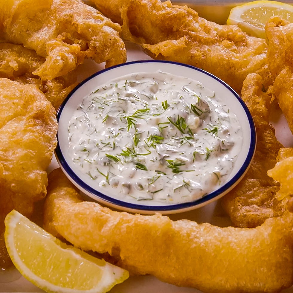 fried fish served with tartar sauce and lemon slices