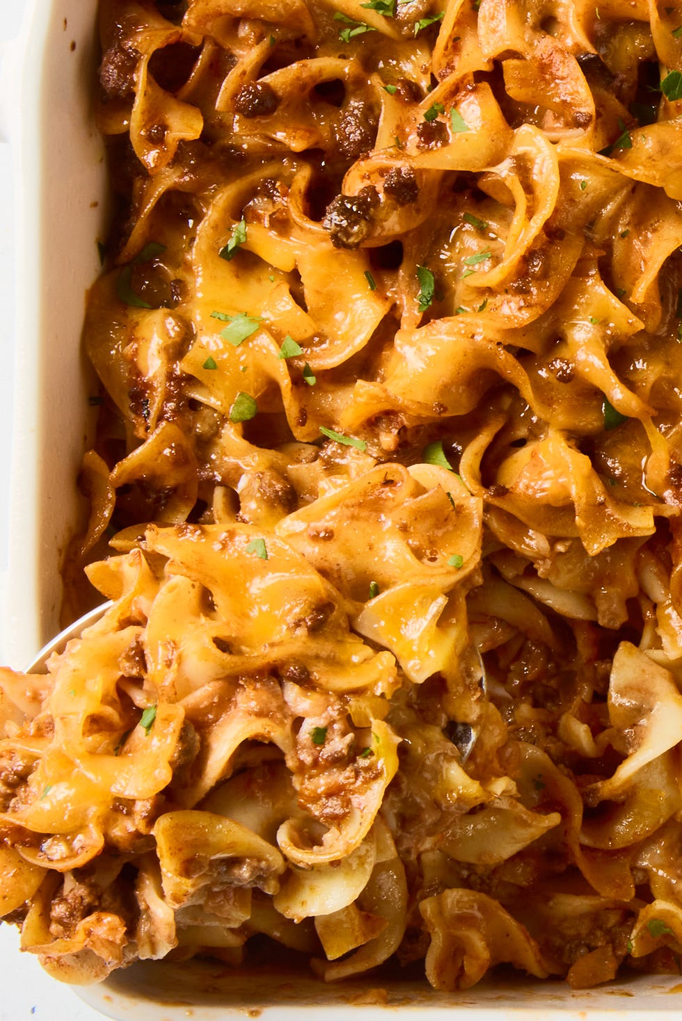 Beef noodle casserole beef noodle casserole topped with cheese in a baking dish