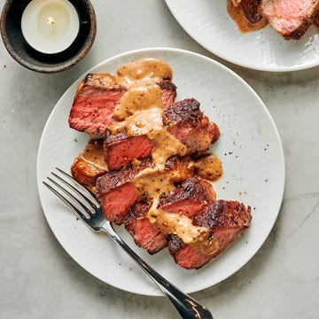 sliced steak with bourbon garlic cream sauce on a white plate
