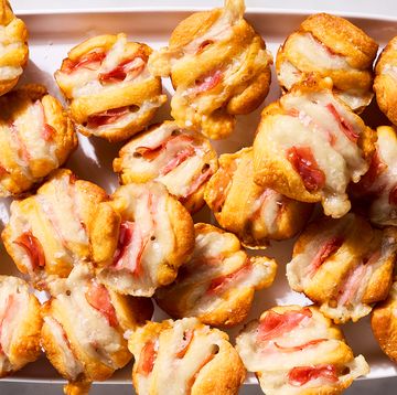 ham and swiss hasselback biscuit bites on a white tray with a bowl of wholegrain dijon mustard