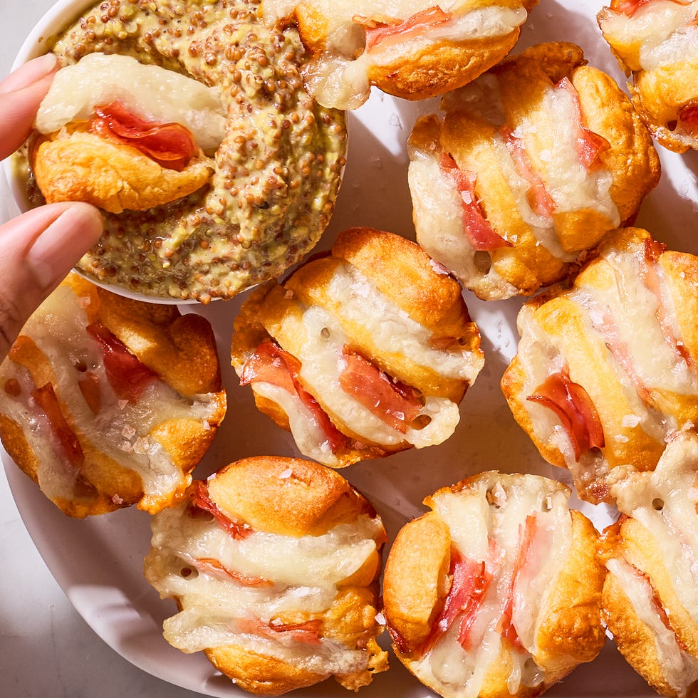 ham and swiss hasselback biscuit bites on a plate with a bowl of wholegrain dijon mustard