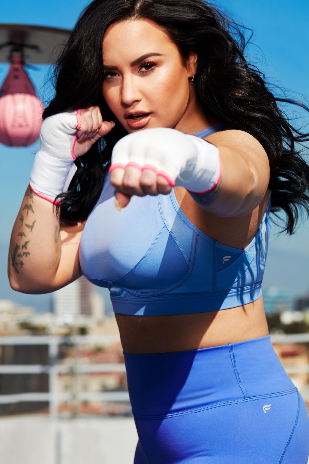 Demi Lovato for Fabletics black jacket and sports bra and neon