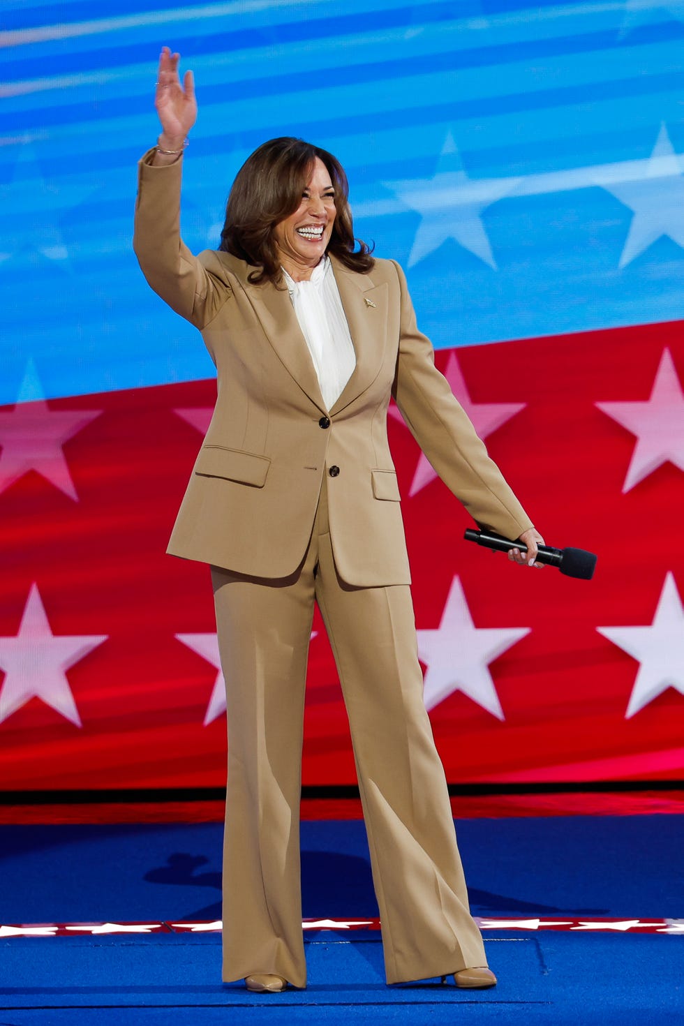 kamala harris on stage at the dnc in a tan suit