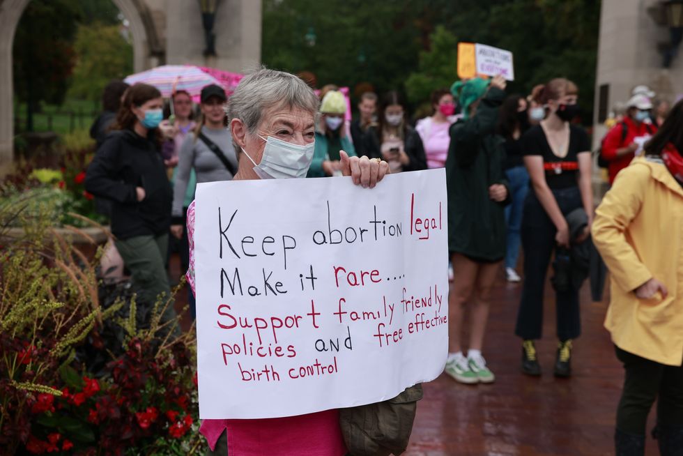 a demonstrator holds a placard expressing her opinion as