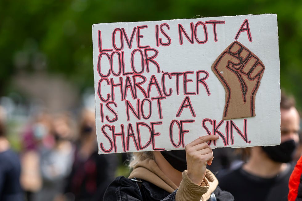 sign reading 'love is not a color character is not a shade of skin'