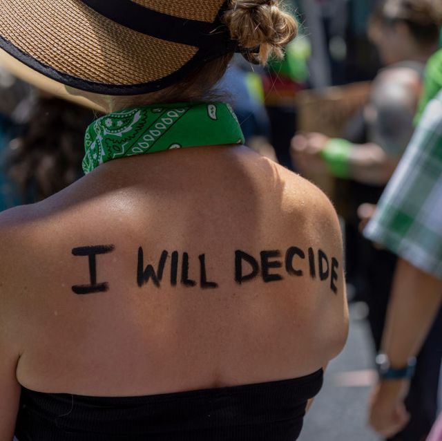 een vrouw schrijft i will decide op rug tijdens demonstratie birth control