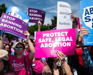 Demonstrators seen holding placards during the "Stop The...