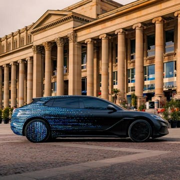 a black sports car parked in front of a building with columns
