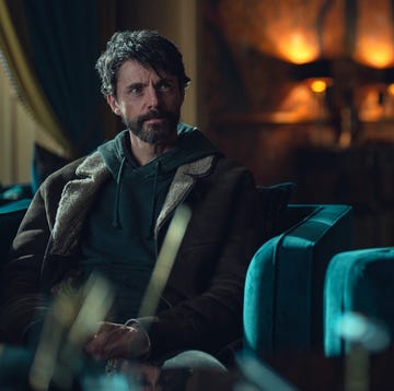Dept Q season 2 two individuals seated in a formal interior setting engaging in conversation