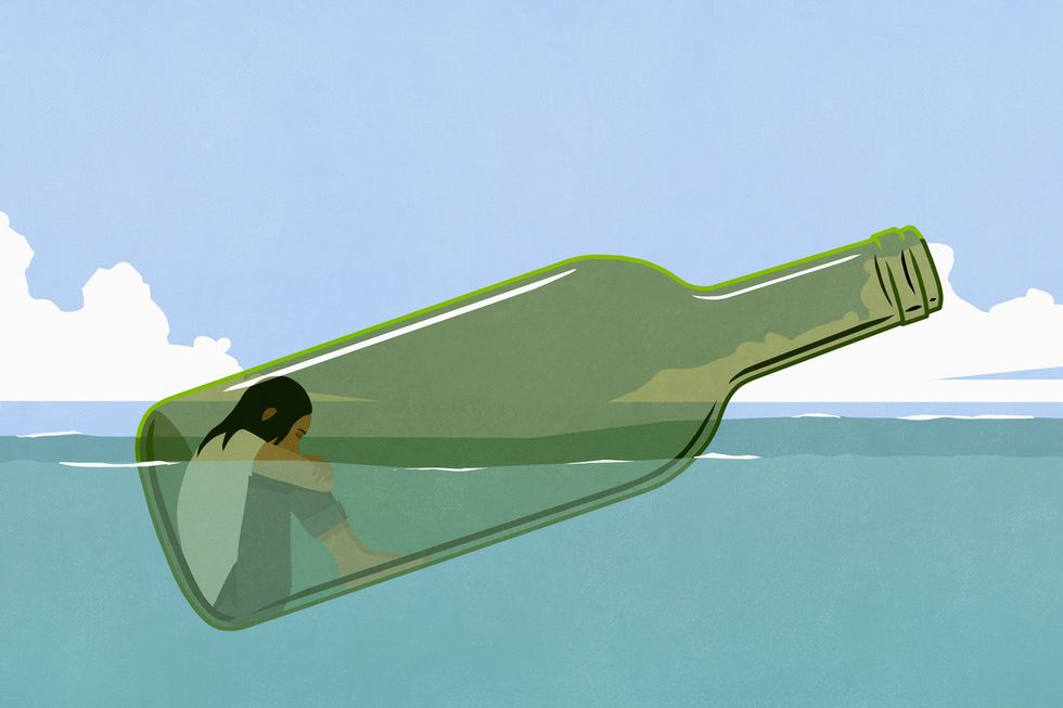 depressed woman inside glass bottle floating in sea