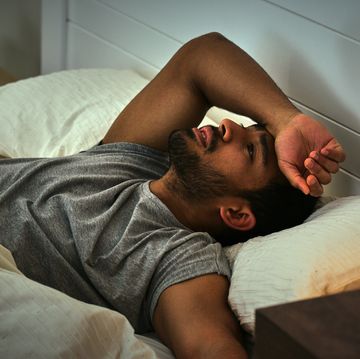 depression, thinking and asian man in a bed with insomnia, fatigue or ptsd memory anxiety burnout, conflict and male person in a bedroom with overthinking stress, fear or mistake trauma in a house