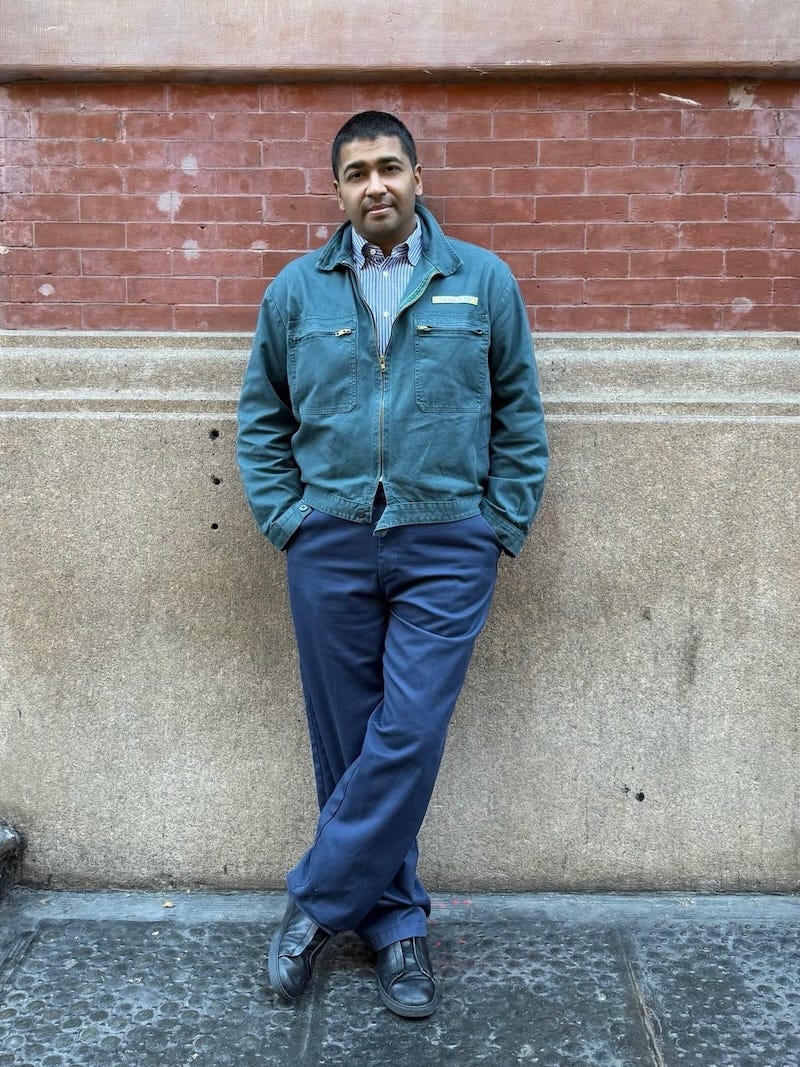 individual leaning against a brick wall