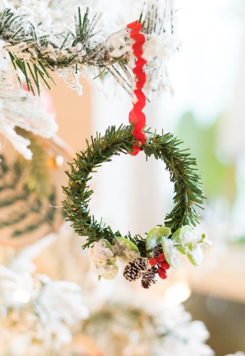 mason jar ring ornament covered in faux greenery to look like a little wreath hanging on a tree