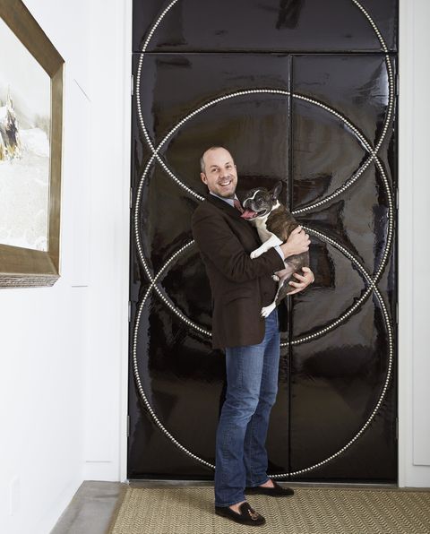 new york– based designer harry heissmann holding a dog