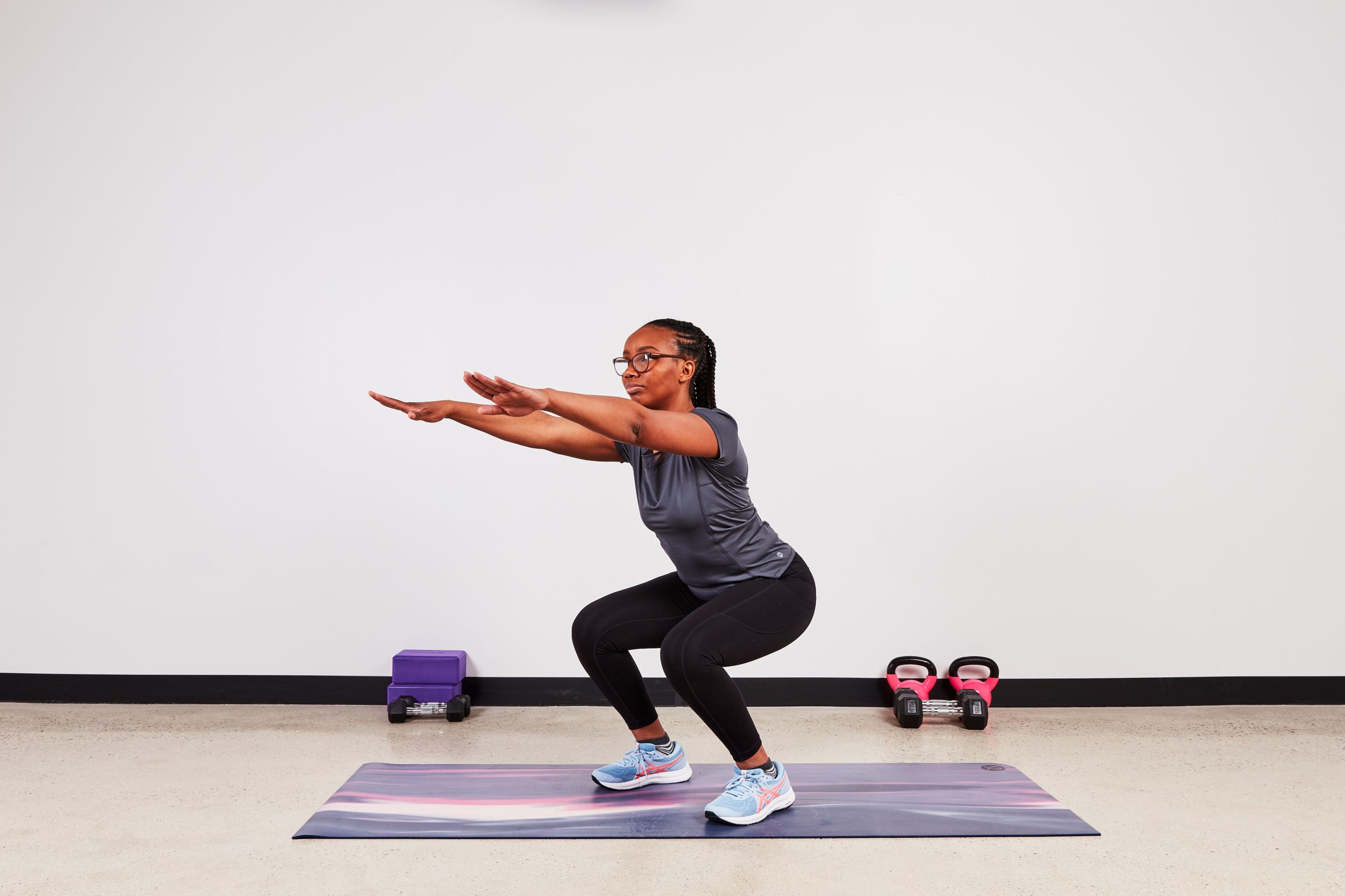 Monique Lebrun performing a squat as part of the desk exercise series