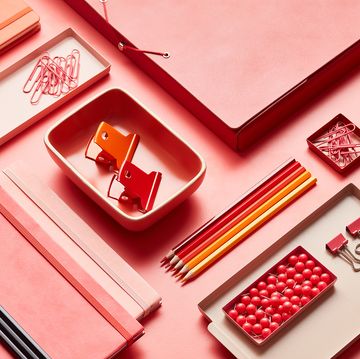 pink and red office supplies in desk organizers