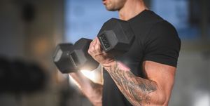 Determined Caucasian Male Athlete Working Out with Dumbbells