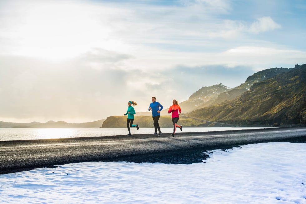 determined friends running on road during winter