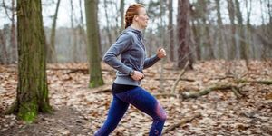 determined woman jogging in forest