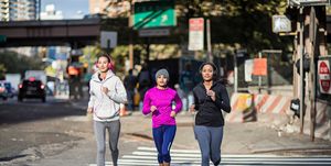 Determined young women jogging on crosswalk