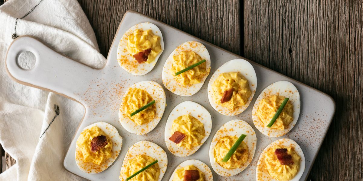 deviled eggs on white ceramic tray with dish towel