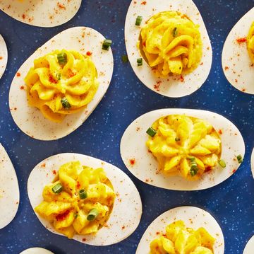 deviled eggs piped in a star shape with paprika and chives