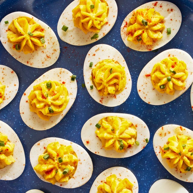 deviled eggs piped in a star shape with paprika and chives