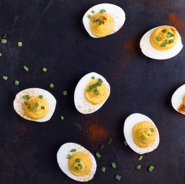 Deviled eggs topped with green onion and paprika