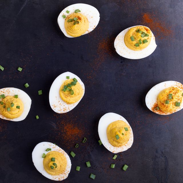 Deviled eggs topped with green onion and paprika