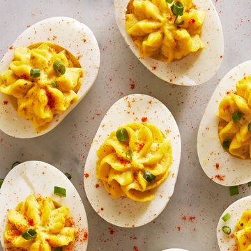 deviled eggs piped in a star shape with paprika and chives