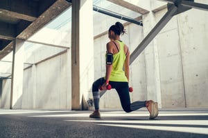 een vrouw voert een lunge uit in de sportschool