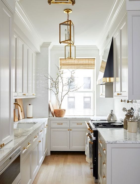 cocina pequeña y estrecha en blanco con estores de ratan