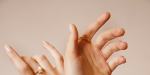 woman's hands with gold jewelry