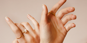 woman's hands with gold jewelry