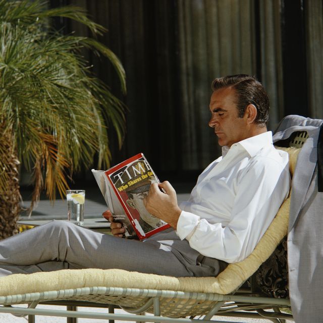 scottish actor sean connery relaxes on the set of the james bond film 'diamonds are forever', usa, may 1971 he is reading the 12th april 1971 edition of 'time' magazine, with lieutenant william calley jr on the cover photo by anwar husseingetty images